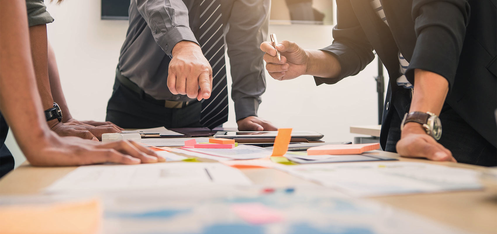 Two accountants discuss documents set on a table.